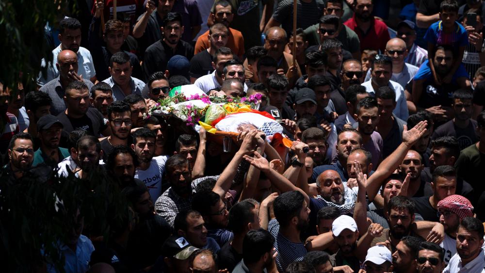 Palestinians carry the body of Mohammed al-Alami, 12, during his funeral in the village of Beit Ummar, Thursday, July 29, 2021. (AP Photo/Majdi Mohammed)
