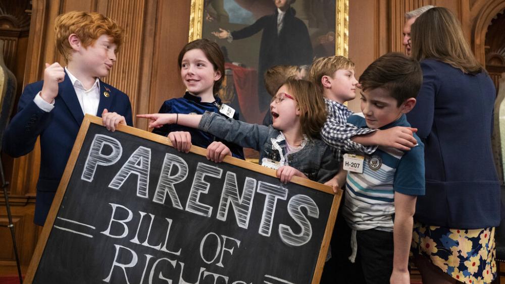 Children play with a chalkboard sign as Speaker of the House Kevin McCarthy, right, speaks with a parent after an event about proposed legislation dubbed the &quot;Parents Bill of Rights,&quot; March 1, 2023, on Capitol Hill. (AP Photo/Jacquelyn Martin)