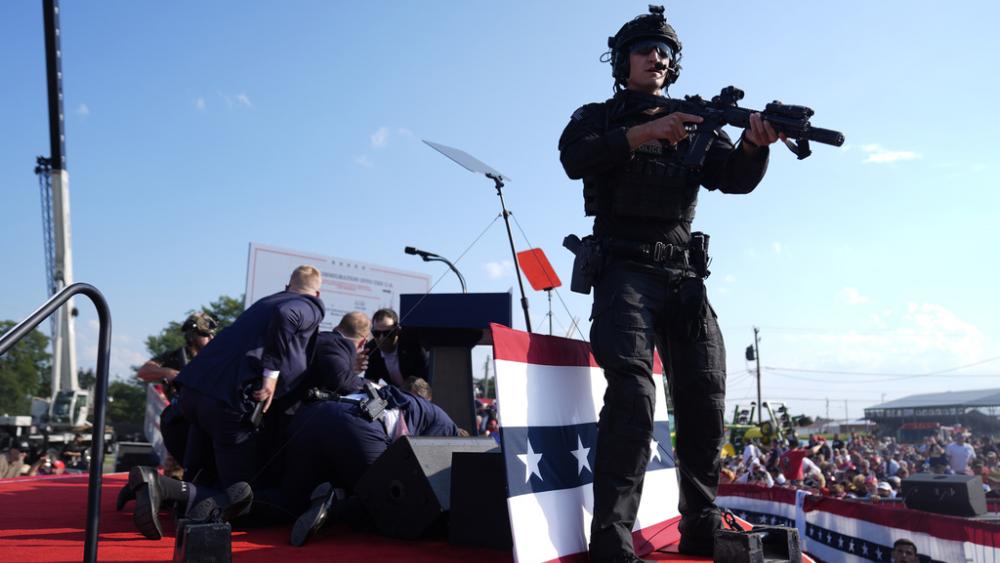 Republican presidential candidate former President Donald Trump is covered by U.S. Secret Service agents at a campaign rally, Saturday, July 13, 2024, in Butler, Pa. (AP Photo/Evan Vucci)