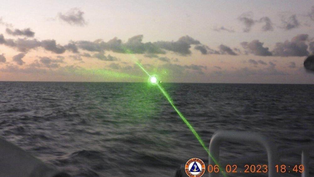 A Chinese coast guard ship aims a green military-grade laser light at a vessel in the disputed South China Sea. (Philippine Coast Guard via AP)