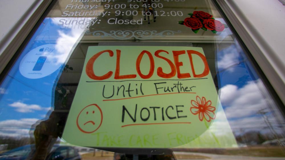 A sign announces a coronavirus closure at a flower shop in Jay, Maine, April 16, 2020. (AP Photo/Robert F. Bukaty)